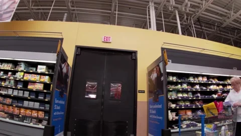 Walmart super center interior senior shopper and cart full of trash Stock Footage 157659752