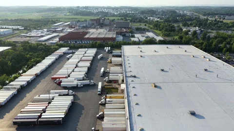 Walmart trailer sits among rows of trucks at loading docks beside warehouse in Stock Footage 340971060