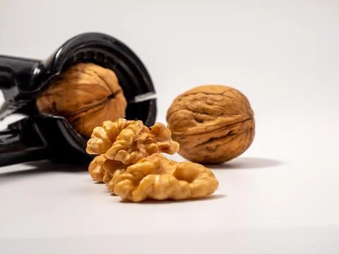 Walnut and nutcracker on a white background. Raw walnut. Stock Photos