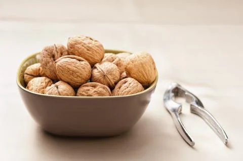 Walnut in a bowl with nutcracker Stock Photos