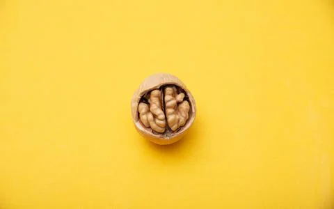 Walnut with broken shells on a yellow background, close-up. Walnut resembling a Photos