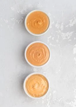 Walnut butter made of peanuts, almonds and walnut on a grey background. Фото