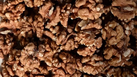 Walnut Halves Spinning on Dark Surface. Top-Down Seamless Motion Loop Stock Footage 325424682