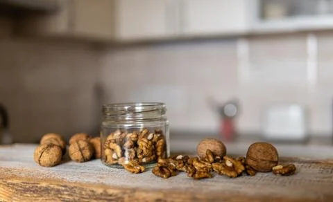 Walnut in a jar and scattered nuts which standing on a white vintage table with Stock Photos