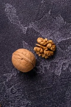 Walnut kernel and whole walnut on blue slate surface. Healthy nuts and seeds Stock Photos