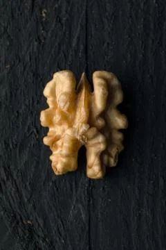 Walnut Kernel On Black Wood Stock Photos