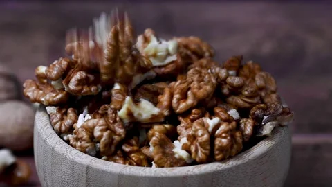 Walnut kernel macro shot. Falling walnuts, wooden bowl, dark moody background Stock Footage 261814622