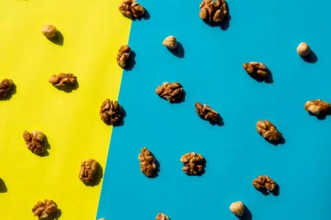 Walnut kernel pattern backdrop. One open nut shell with kernel on yellow blue Stock Photos