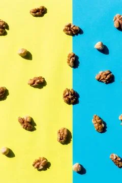 Walnut kernel pattern backdrop. One open nut shell with kernel on yellow blue Stock Photos