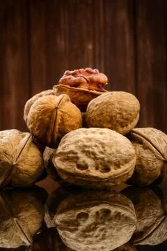 Walnut kernels and whole walnuts on rustic wooden background Stock Photos