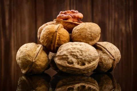 Walnut kernels and whole walnuts on rustic wooden background Stock Photos