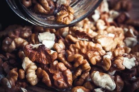 Walnut kernels and whole walnuts wood background Stock Photos