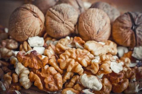 Walnut kernels and whole walnuts wood background Stock Photos