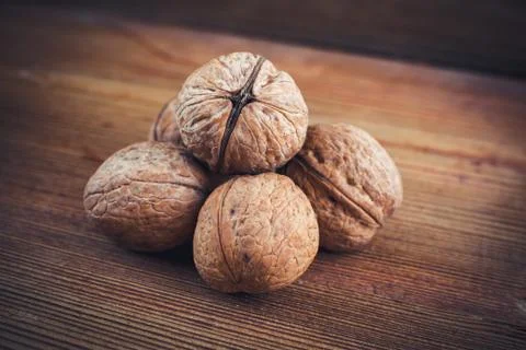 Walnut kernels and whole walnuts wood background Stock Photos