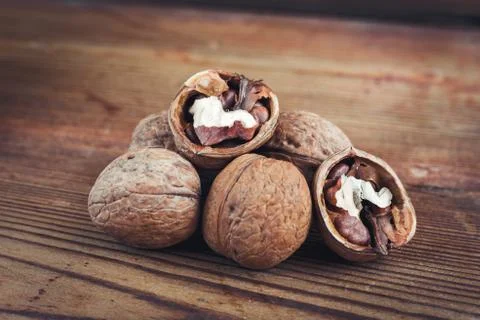Walnut kernels and whole walnuts wood background Stock Photos