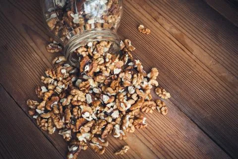 Walnut kernels and whole walnuts wood background Stock Photos