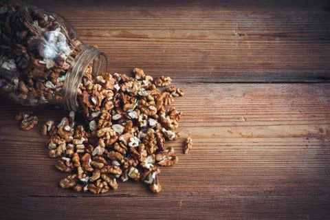 Walnut kernels and whole walnuts wood background Stock Photos