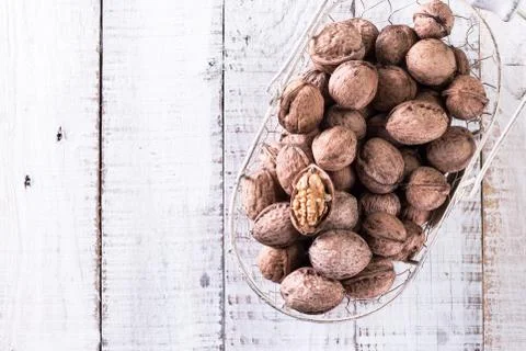 Walnut kernels and whole walnuts on rustic old wooden table Stock Photos