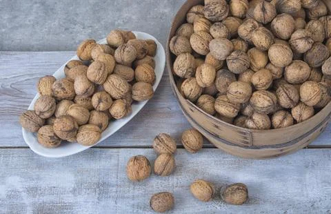 Walnut kernels and whole walnuts on the rustic grunge  table. Stock Photos