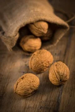 Walnut kernels and whole walnuts on rustic old oak table Stock-Fotos
