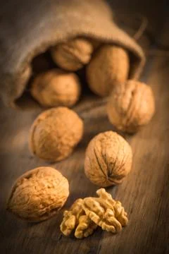 Walnut kernels and whole walnuts on rustic old oak table 스톡 사진