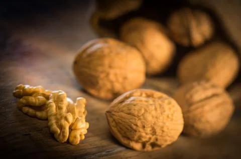 Walnut kernels and whole walnuts on rustic old oak table Stock-Fotos