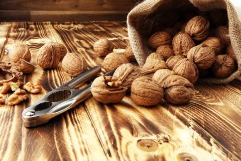 Walnut kernels and whole walnuts on table with a nutcracker Stock Photos