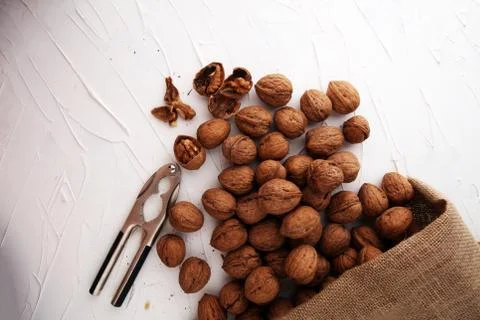 Walnut kernels and whole walnuts on table with a nutcracker Stock Photos