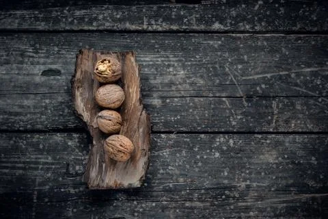 Walnut kernels and whole walnuts on rustic old wooden table Stock Photos