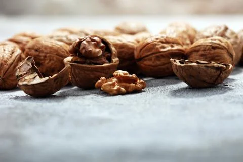 Walnut kernels and whole walnuts on rustic old table Stock Photos