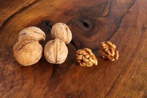 Walnut kernels and whole walnuts on rustic old wooden table, Tasty walnuts on Stock Photos