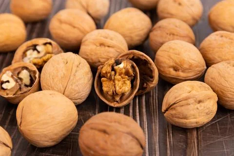 Walnut kernels and whole walnuts on a rustic old wooden table. Foto stock