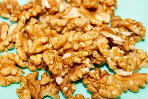 Walnut kernels are piled up in a close-up on a turquoise background. Fotos Stock