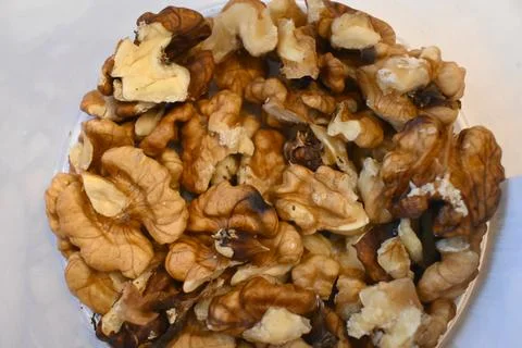 Walnut kernels arranged on a white surface Stock Photos