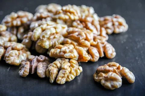 Walnut kernels on a black table Stock Photos