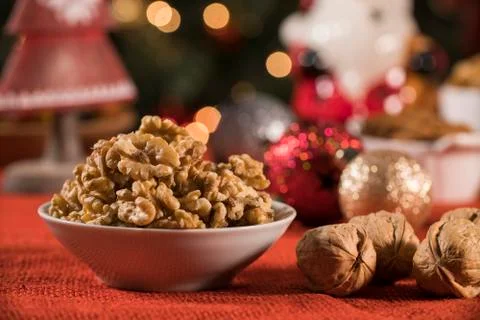 Walnut kernels into a bowl on rustic old wooden table with christmas backgrou Stock Photos