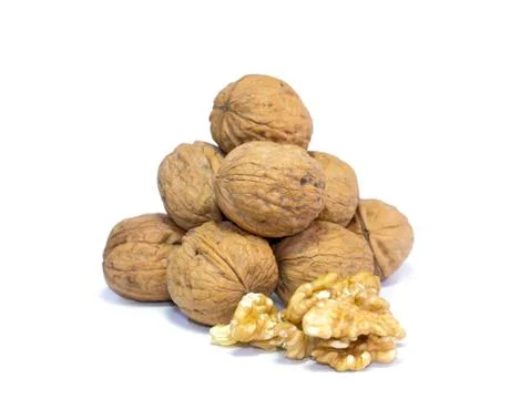 Walnut kernels in front of pyramid of walnut shells isolated on white background Stock Photos