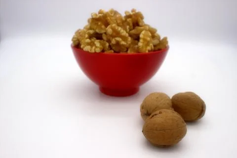 Walnut Kernels In Red Bowl (Other Names: Juglans Regia, Persian Walnut, Engli Stock Photos