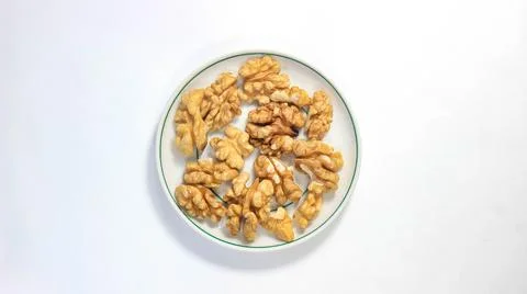Walnut kernels in a saucer on the table. Stock Photos