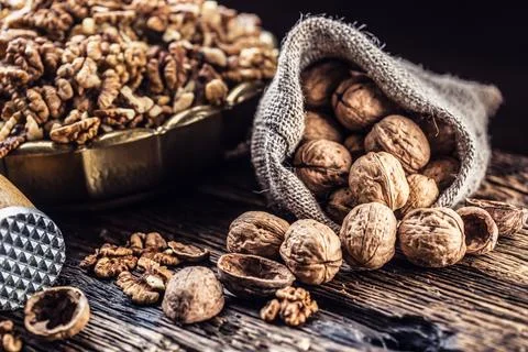 Walnut kernels whole walnuts in burlap sack and vintage bowl Stock Photos