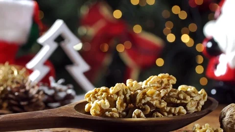 Walnut kernels into a wood spoon on rustic old wooden table with christmas ba Stock Footage 83552141