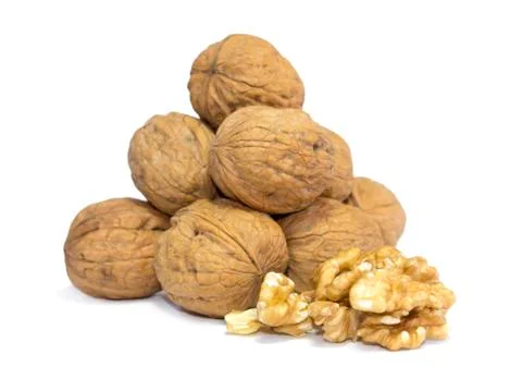 Walnut meat in front of pile of walnut shells isolated on white background Stock Photos