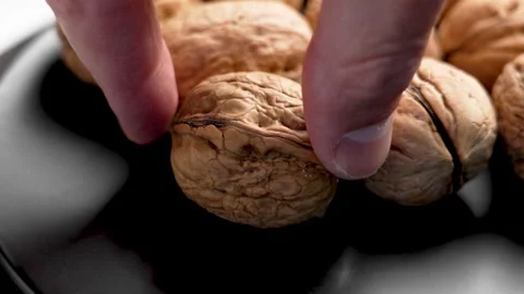 Walnut with nutshell textures. Cook hand takes organic nut Stock Footage 283576339