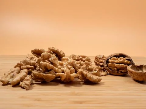 Walnut on an orange background. Raw walnut. Stock Photos