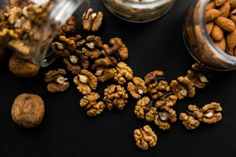 Walnut scattered on the black table from a jar. Walnut is a healthy vegetarian Stock Photos