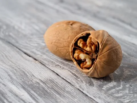 Walnut with shell on wooden background. Stock Photos