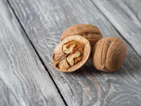 Walnut with shell on wooden background. Stock Photos