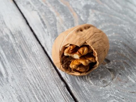 Walnut with shell on wooden background. Stock Photos