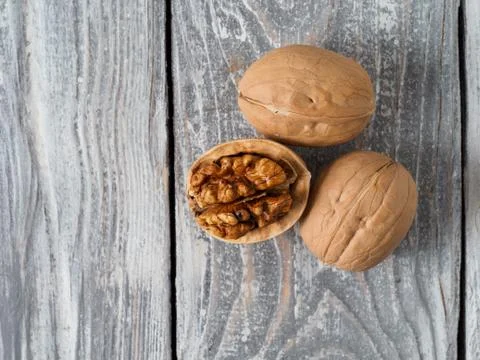Walnut with shell on wooden background. Stock Photos