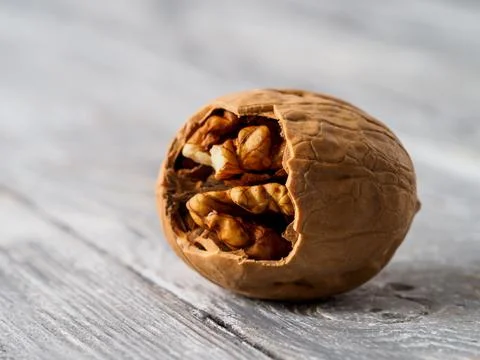 Walnut with shell on wooden background. Stock Photos